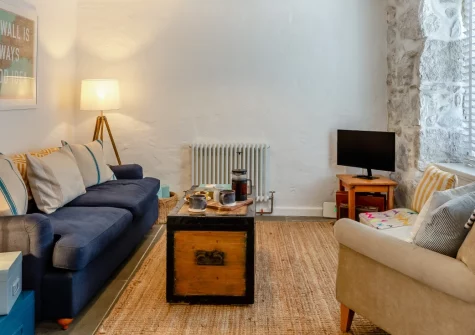Minmar Cottage, St Ives is a charming two-bedroom fisherman's cottage showcasing traditional Cornish character with exposed granite walls, wood burner, and sunny courtyard garden, perfectly positioned in the heart of this celebrated artists' town.