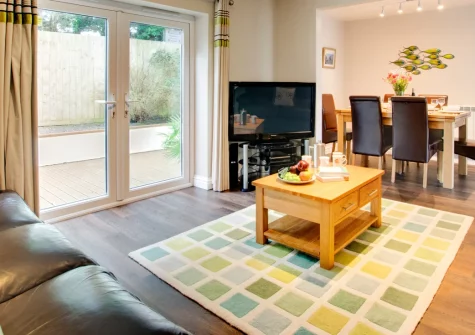 Minnows, Tregolds is a light-filled contemporary house just two miles from Cornwall's dramatic coast, featuring flexible sleeping arrangements, an enclosed decked patio, and easy access to St Merryn's seven beautiful bays and Padstow beyond.