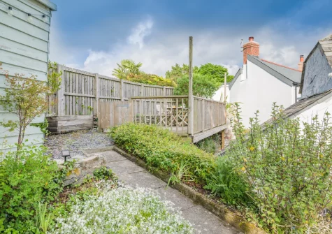 The terraced garden with decked patio, barbecue & alfresco dining area at Molesworth Cottage, Egloshayle