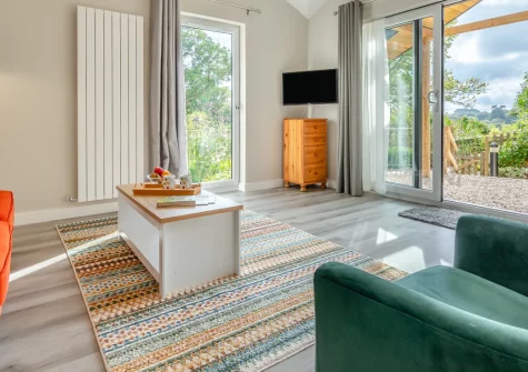 Monterey at Polsue Gardens, Tresillian is a charming contemporary wooden cabin set in peaceful countryside gardens near Truro, featuring a covered outdoor dining area, spacious interiors with garden views, and easy access to both coast and moor.