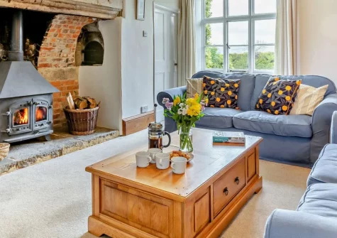 Newhouse, Musbury is a beautiful traditional Devon longhouse with panoramic countryside views and walks from the door, featuring characterful interiors, wood burner, and private gardens with barbecue, close to sandy beaches at Seaton and Lyme Regis.