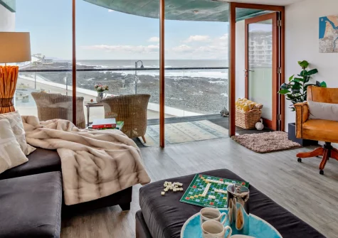 No4 The Ho, Westward Ho! is a stunning beachfront apartment with panoramic bay views, contemporary interiors, and a spacious west-facing balcony perfect for sunset dining, positioned just steps from two miles of golden sand and surf.