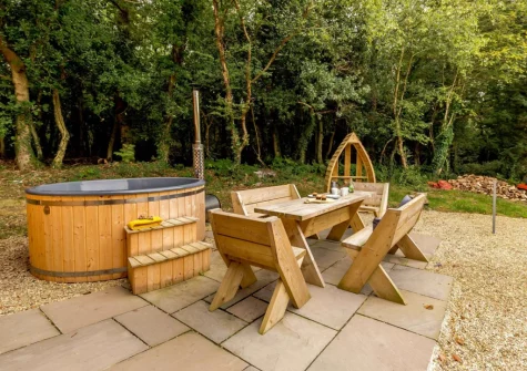 The patio, alfresco dining area & wood-fired hot tub at Oak Cabin at Hilton Wood, Whitstone