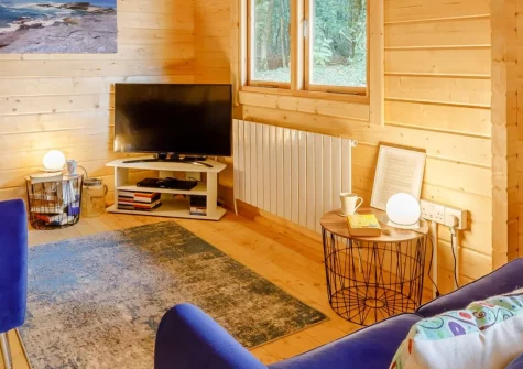 Oak Cabin at Hilton Wood, Whitstone is a contemporary two-bedroom woodland retreat featuring a private wood-fired hot tub, peaceful forest setting, upstairs balconies with countryside views, and easy access to North Cornwall's stunning beaches.