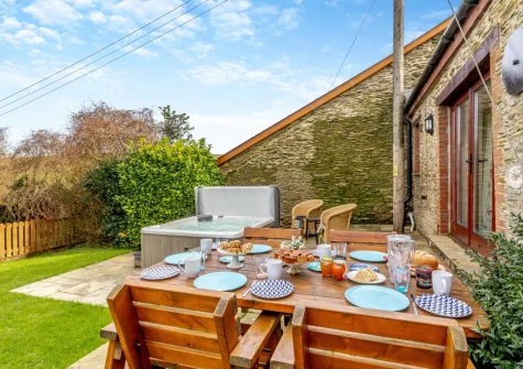 The patio, barbecue, alfresco dining area, hot tub & garden at Oriel Cottage, Muddiford