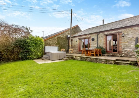The patio, barbecue, alfresco dining area, hot tub & enclosed garden at Oriel Cottage, Muddiford