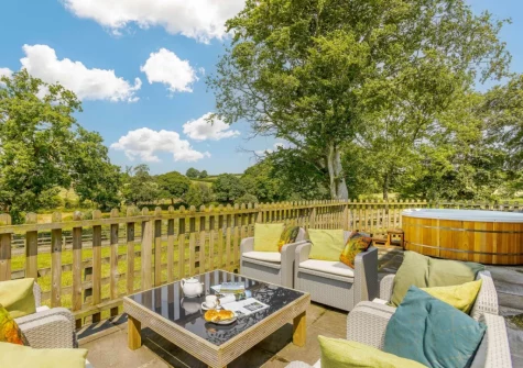 The patio, outdoor sitting area & hot tub at Otter Barn Lakes, St Giles-on-the-Heath
