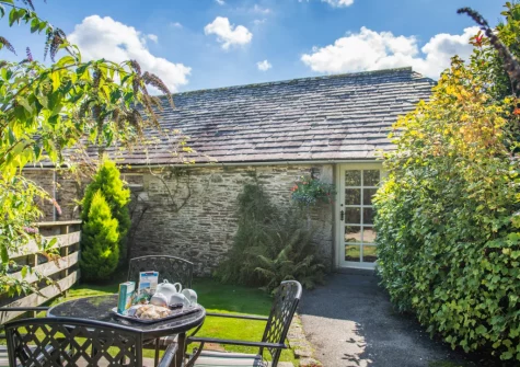 The patio, alfresco dining area & enclosed garden at Otterbridge at Penrose Burden, St Breward
