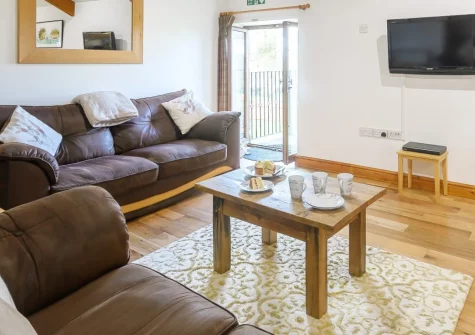 Owls Nest at Hilltown Farm, Mariansleigh is a beautifully converted barn on a peaceful Devon farm, featuring a private hot tub, enclosed garden, six acres for dog walking, and easy access to Exmoor's dramatic moorland just 12 miles away.