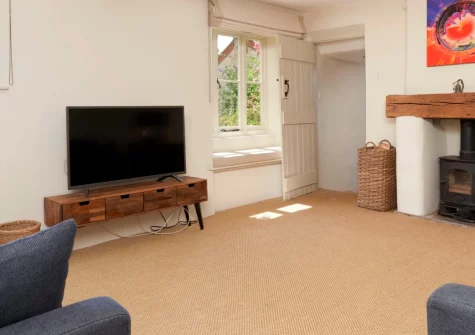 Palmers Cottage, Dalwood is an enchanting, three-bedroom, 18th-century thatched retreat in the Blackdown Hills AONB, featuring exposed beams, a light-filled kitchen with glass ceiling, separate snug, & an enclosed garden with summer house & decking.