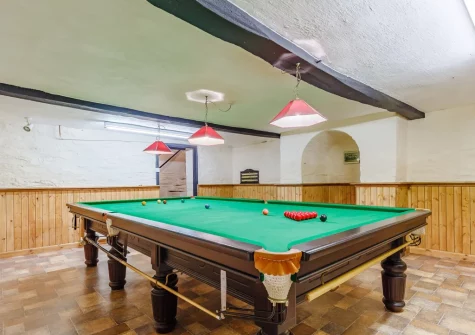 The snooker room, with a full-sized snooker table, at Pendavey Farm House, Sladesbridge