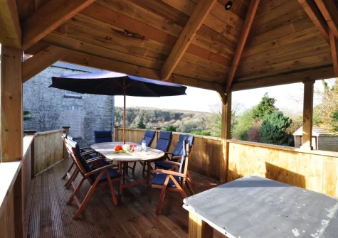 The decked patio & alfresco dining area at Pendavey Farm House, Sladesbridge