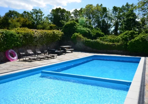 The heated outdoor swimming pool, with separate shallow end suitable for children, at Pendavey Farm House, Sladesbridge