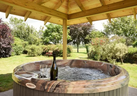 The patio & covered hot tub at Pendavey Lodge, Sladesbridge