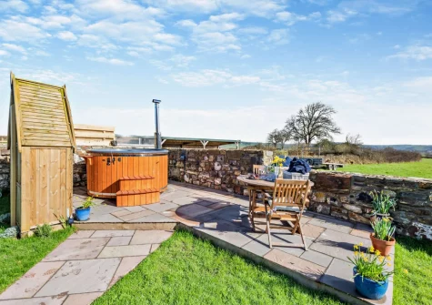 The wood-fired hot tub, patio, alfresco dining area & enclosed garden at Penhill Tack Room, Fremington