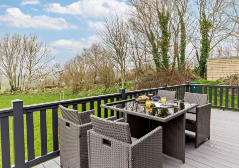 The wrap-around decked terrace & alfresco dining area at Penmarlam Lodge, Lanteglos