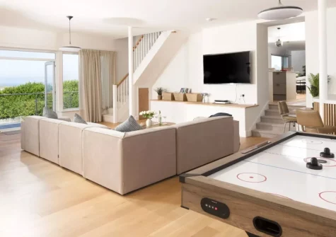 Pentire Beach House, Newquay is a stunning four-bedroom coastal retreat overlooking Fistral Beach, featuring a private garden gate to the sand, sweeping sea views, and stylish interiors ideal for family holidays and gatherings with friends.