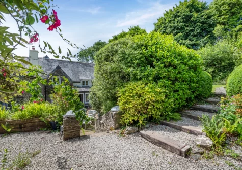 From the patio & alfresco dining area, steps lead up to the lawned garden