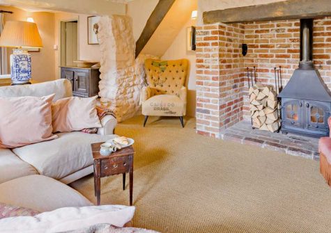 Pitt Cottage, Branscombe is an enchanting 18th-century thatched retreat in the East Devon Area of Outstanding Natural Beauty, featuring characterful beamed interiors, warming wood burner, enclosed garden with deck, and beach on the doorstep.