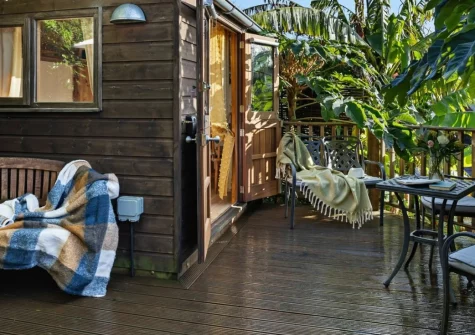 Poldhu at the Buryas Bridge Collection, near Penzance, is a magical shepherd's hut wrapped in tropical greenery. Enjoy a private sun-soaked deck, cosy interiors, and easy access to Cornwall's beaches, coastal villages, and celebrated attractions.