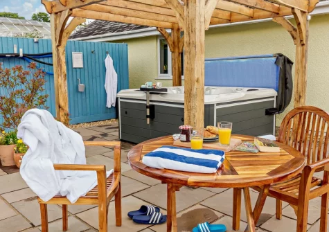 The private enclosed patio, barbecue, alfresco dining area & hot tub at Pool Lodge, Cargreen