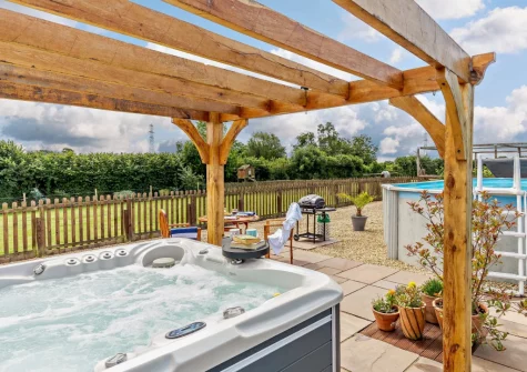 The private enclosed patio, barbecue, alfresco dining area & hot tub at Pool Lodge, Cargreen