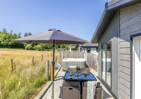 The patio, alfresco dining area & hot tub at Poppy, 5 Roadford Lakes Lodges, Broadwoodwidger