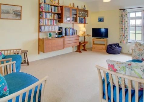 Porghelly Cottage, Harlyn is a charming reverse-level retreat 800 metres from Harlyn Bay's golden sands, featuring sea glimpses from the bright first-floor lounge, exposed timber beams throughout, and easy access to the dramatic coastline.