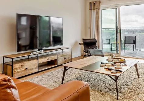 Portside, Polruan is an elegant five-bedroom house offering spectacular sea views from its private balcony. This stylish coastal retreat combines modern luxury with traditional Cornish charm, perfect for families seeking memorable holidays.