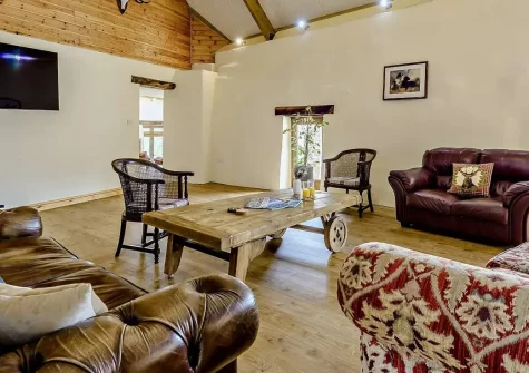 Priestacott Tithe Barn, Torrington is a splendid six-bedroom barn conversion on a working farm, featuring a wood-fired hot tub, beautiful grounds and easy access to North Devon's beaches and attractions. Perfect for large family gatherings.