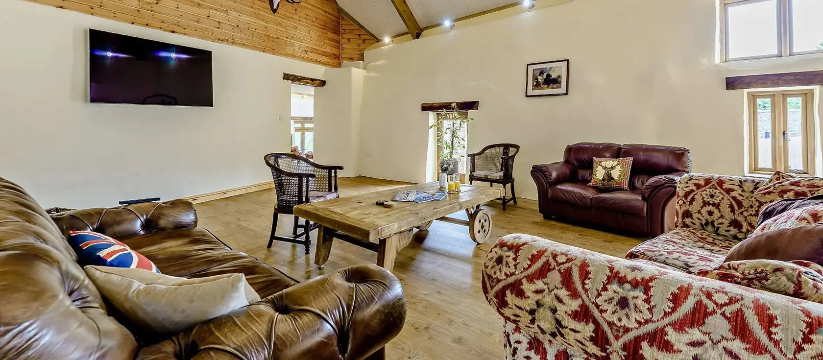 Priestacott Tithe Barn, Torrington is a splendid six-bedroom barn conversion on a working farm, featuring a wood-fired hot tub, beautiful grounds and easy access to North Devon's beaches and attractions. Perfect for large family gatherings.