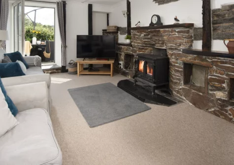 Primrose Cottage, Treyarnon is a beautifully restored 400-year-old cottage sleeping ten, just a short stroll from the beach, offering a wood-burning stove, games room, sun-soaked terrace, and lush garden with mature apple trees for lazy summer days.