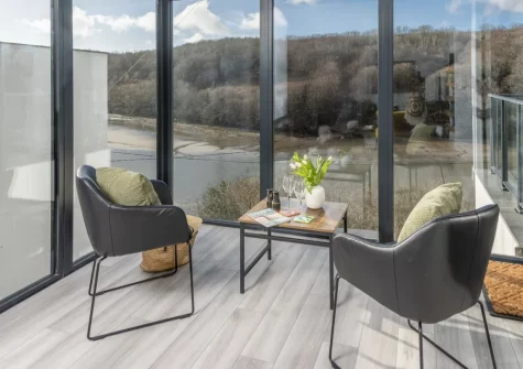 Redshank, Looe is a striking four-bedroom coastal house rising dramatically above the estuary, featuring spectacular water views from multiple balconies, a cinema room, games room, and boutique-style interiors, all within easy reach of the beach.