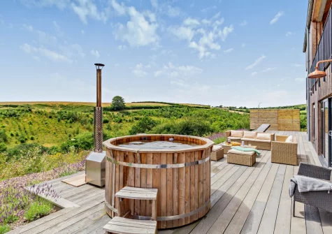 The wood-fired hot tub, decked patio & outdoor sitting area at Riverview Farmhouse, Paynter's Cross