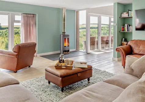 Riverview Farmhouse, Paynter's Cross is a stunning six-bedroom barn conversion on a 280-acre organic farm. Enjoy breathtaking Tamar Valley views, a private hot tub, tennis court, and games room. Perfect for unforgettable family gatherings.