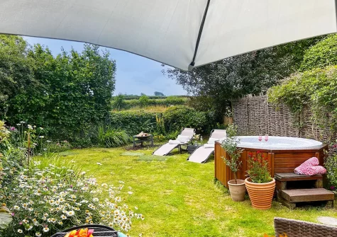 The garden & hot tub at Rose Week Cottage, Langtree