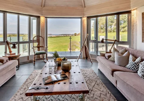 Roundhouse Mill, St Issey is an exceptional five-bedroom barn conversion for ten guests with panoramic estuary views, a heated hot tub, and a stunning garden retreat. Perfect for creating unforgettable group holidays on the North Cornish coast.