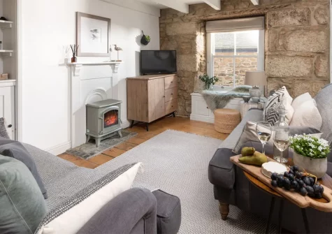 Salt Loft, Mousehole is a two bedroom two bathroom Grade II listed cottage steps from the harbour, pubs, cafes & shops. Modern dining kitchen with dishwasher. Living room with stripped wood floors, feature stove & window seat. Sea views from lofty bedrooms.