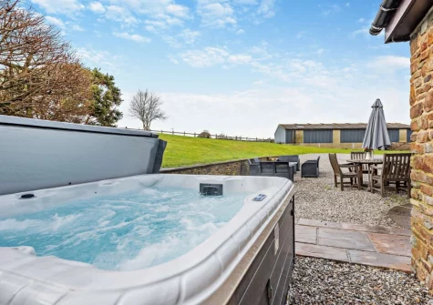 The patio, alfresco dining, outdoor sitting area & hot tub at Salterns River, Weare Giffard