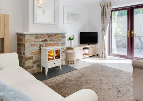 Samphire, Padstow is a charming two-bedroom fisherman's cottage in the heart of this celebrated harbour town, featuring a private suntrap patio, stylish interiors with two en-suite bedrooms, and immediate access to coastal paths and beaches.