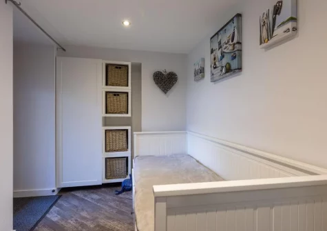 The handy cloakroom with day bed at Sandseekers Barn, Mawgan Porth