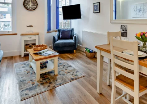 Sea Bass, Brixham is a stylish two-bedroom apartment set above a renowned fish bistro, offering a sunny private patio, nautical-themed interiors and effortless access to the bustling harbour, shops and coastal walks of this lively fishing town.