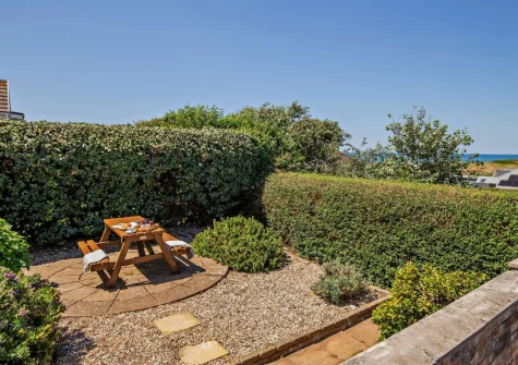 The rear garden & alfresco dining area at Sea Escape, Widemouth Bay