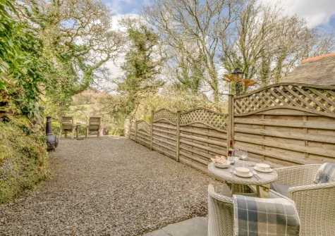 The patio, alfresco dining, chimenea fire pit & outdoor sitting area at Skyber Riverview Barn, Tresarrett