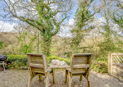 The outdoor sitting area with delightful river views, and direct access to the Camel Trail, at Skyber Riverview Barn, Tresarrett