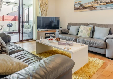 Smithy Cottage, Marazion is a charming three-bedroom cottage near St Michael's Mount, featuring a cosy conservatory, enclosed courtyard garden, driveway parking, distant sea views, and a warm welcome for dogs and families alike on a Cornish break.