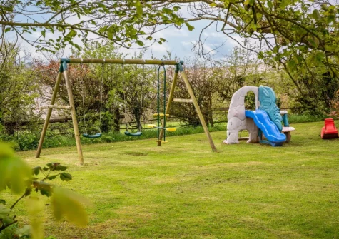 The garden with children's play area at South Blatchborough Manor, Bradworthy