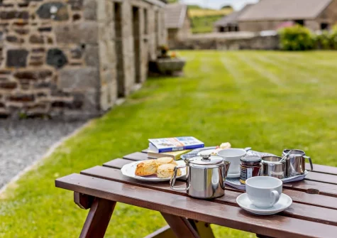 The barbecue, alfresco dining area & large grassed garden at Sowanna Farm Cottage, White Cross
