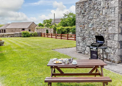 The barbecue, alfresco dining area & large grassed garden at Sowanna Farm Cottage, White Cross