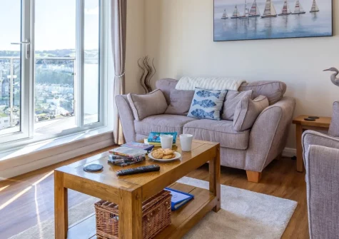 Sulima, Brixham is a stunning second-floor apartment with a sun-soaked glass-fronted balcony offering sea glimpses, contemporary coastal interiors, and private parking, perfectly positioned for exploring the English Riviera's beaches and attractions.